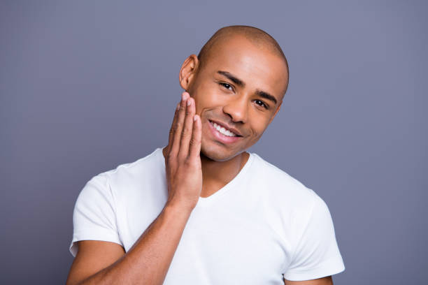 Close up photo of man touching his face