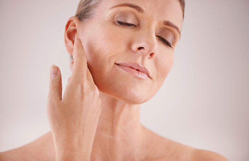 Older woman, touching her face